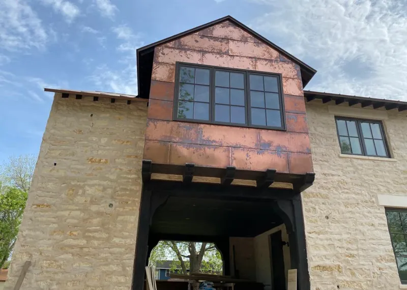 Copper metal panel facade on a stone building for Roof Repair in Maywood